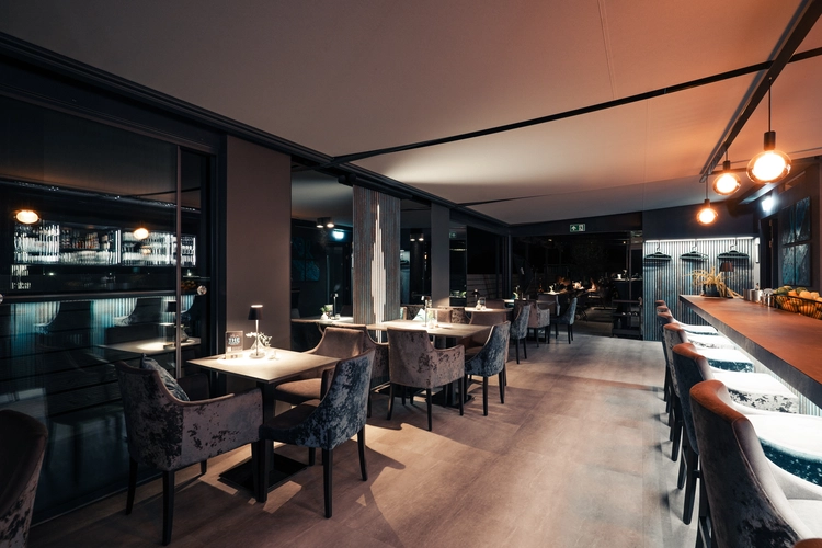 Innere der Location mit Stühlen und Spiegeln, einladend gestaltet